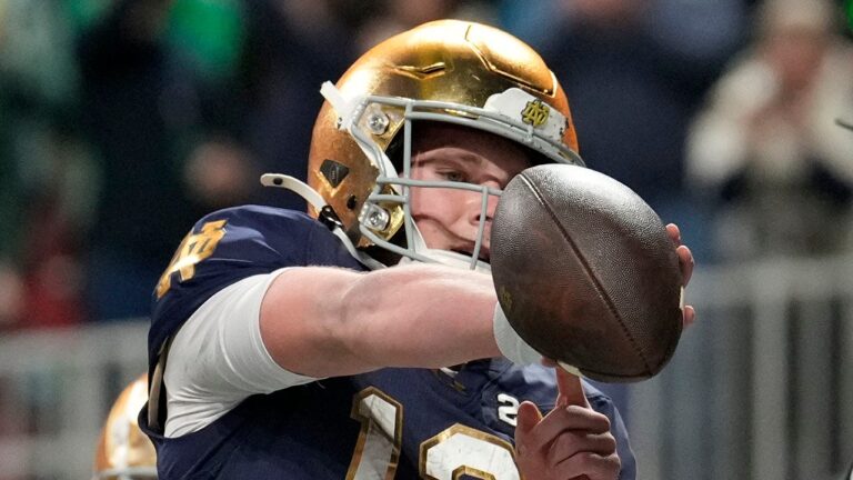 Notre Dame’s Riley Leonard points to a favorite Bible verse after scoring the opening TD in the national title game.